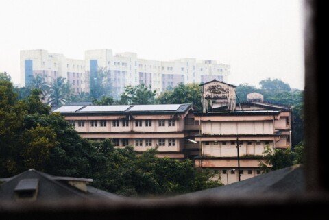 Quiet Indian college campus with academic buildings, representing university hostel accommodation for outstation students