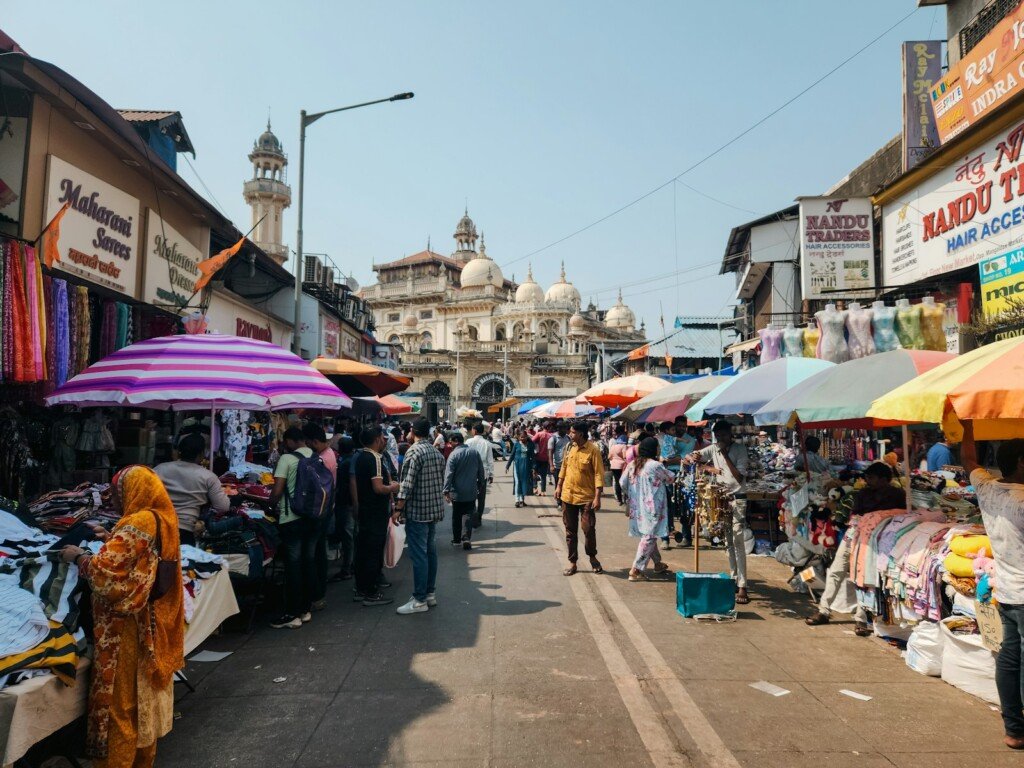 Narrow, crowded wholesale market lane lined with textile and trading shops, similar to Burrabazar in Kolkata