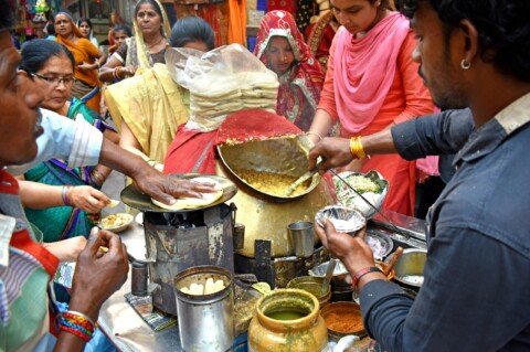 Street food vendor serving snacks at a busy Kolkata-style street stall