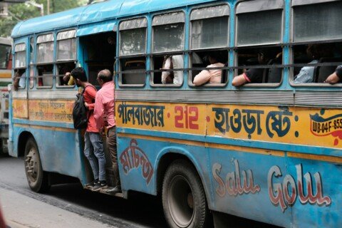Passengers boarding a public bus in Kolkata