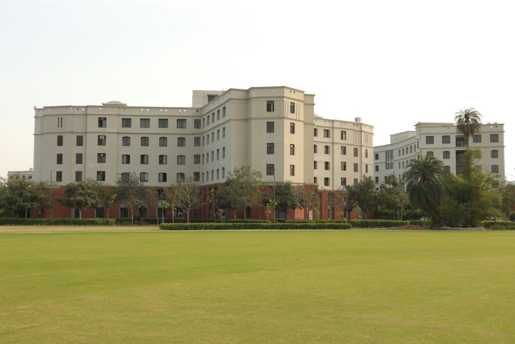 A large university campus building set on a green field in Kolkata