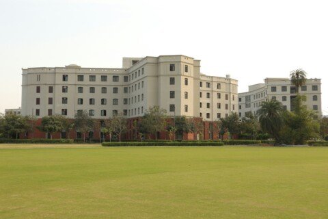 A large university campus building set on a green field in Kolkata