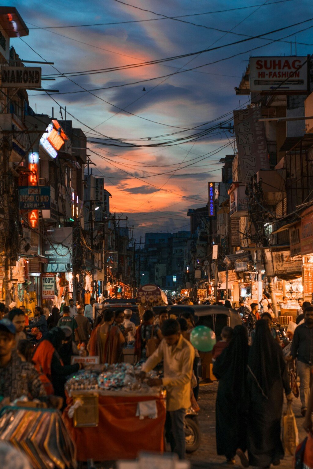 A busy market street at night, similar to New Market in Kolkata