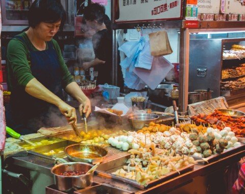 Bamboo steamer baskets of dumplings at a street food stall, similar to the Chinese breakfast stalls at Tiretta Bazaar in Kolkata
