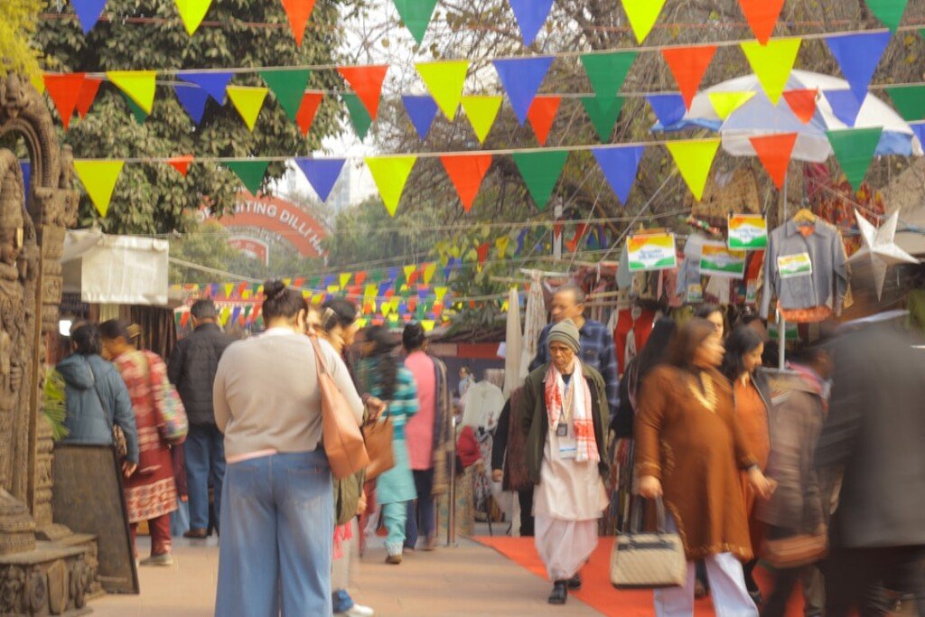 Open-air Indian handicrafts and handloom bazaar with textile stalls, the kind of state emporium shopping found at Dakshinapan Kolkata