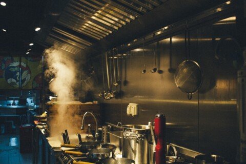 Stainless steel cooking pots on a commercial restaurant kitchen stove