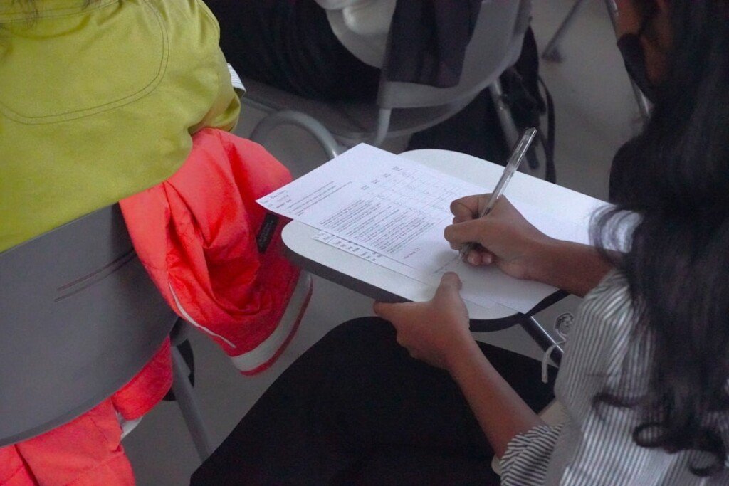 Student writing an examination paper, illustrating the revised WBCHSE HS Semester III routine and Karam Puja holiday on September 22