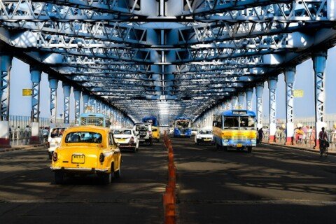 Yellow taxi on a Kolkata street beneath an elevated road, illustrating the Behala and Diamond Harbour Road area where many PGs are located