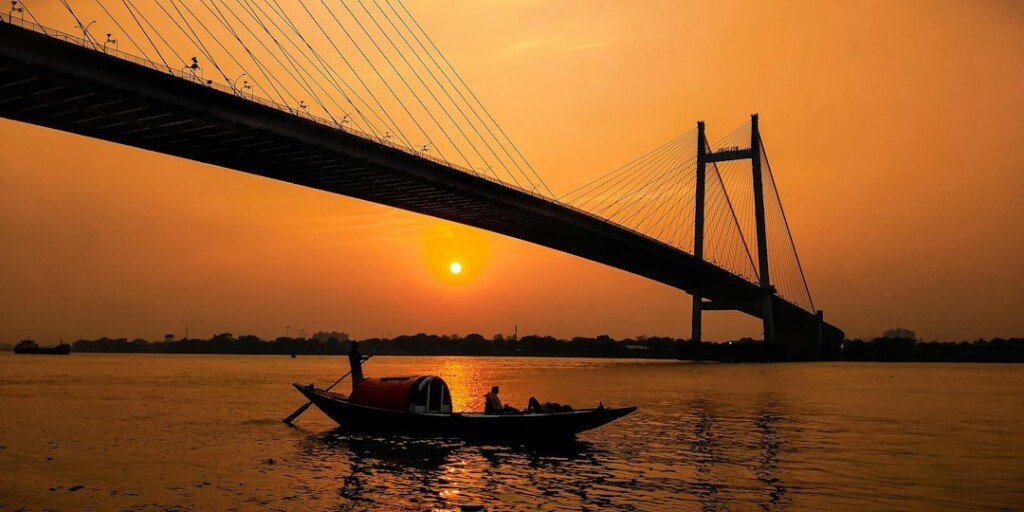Wooden boat on the Hooghly river at Prinsep Ghat Kolkata in the evening with Vidyasagar Setu bridge behind