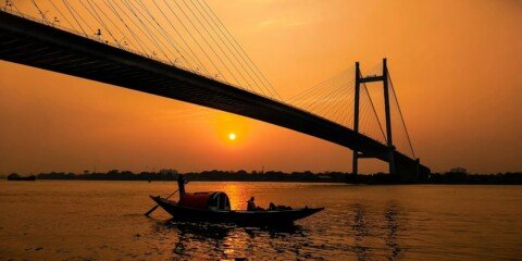Wooden boat on the Hooghly river at Prinsep Ghat Kolkata in the evening with Vidyasagar Setu bridge behind
