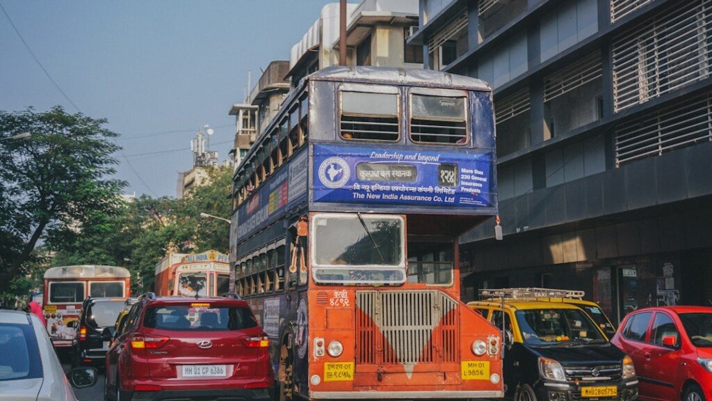 A red and yellow public bus on a city road, illustrating West Bengal government bus complaint helplines