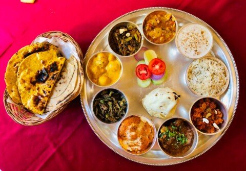 Vegetarian thali served on a stainless steel tray with dal, sabzi, rice and roti at a restaurant in Kolkata