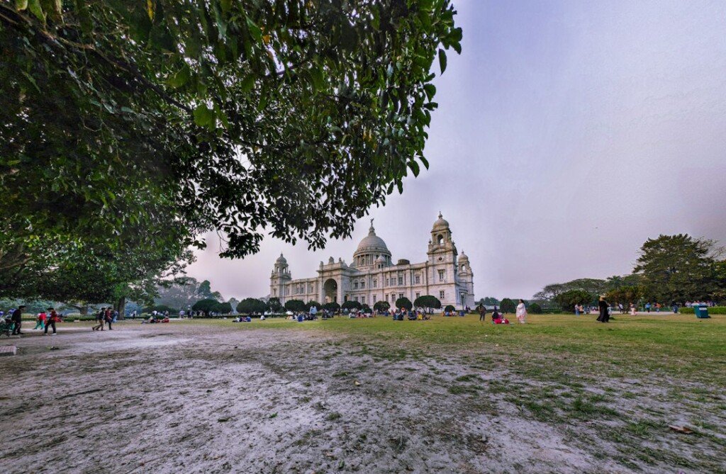 Victoria Memorial in Kolkata surrounded by green trees under a soft winter sky, the best season to visit the city