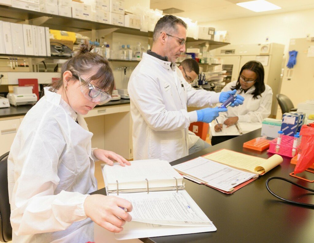 Students learning laboratory procedures, representing B.Pharm practical training