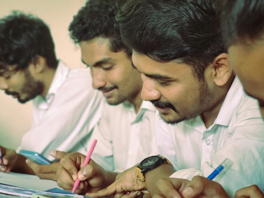 College students taking notes in class, representing BCom colleges in Kolkata