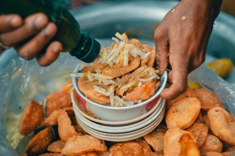Plate of Indian street food snacks served at a roadside stall, similar to Kolkata telebhaja and chops