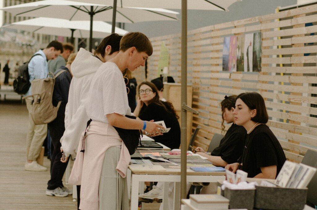 Visitors gathered around a table of books at a book fair