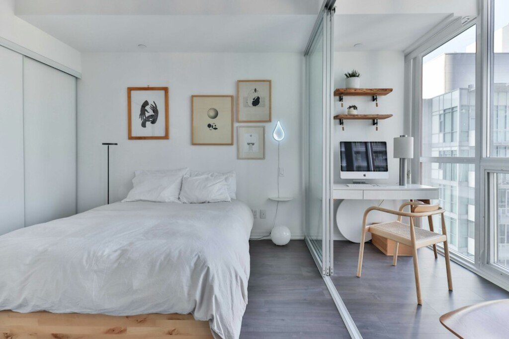 Furnished co-living bedroom with a bed, study desk and window, typical of shared rooms in New Town Kolkata