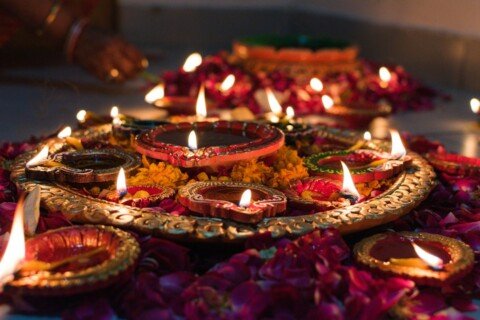 Rows of lit oil lamps and candles glowing at night during an Indian festival, similar to the diyas lit on Kali Puja night in Kolkata