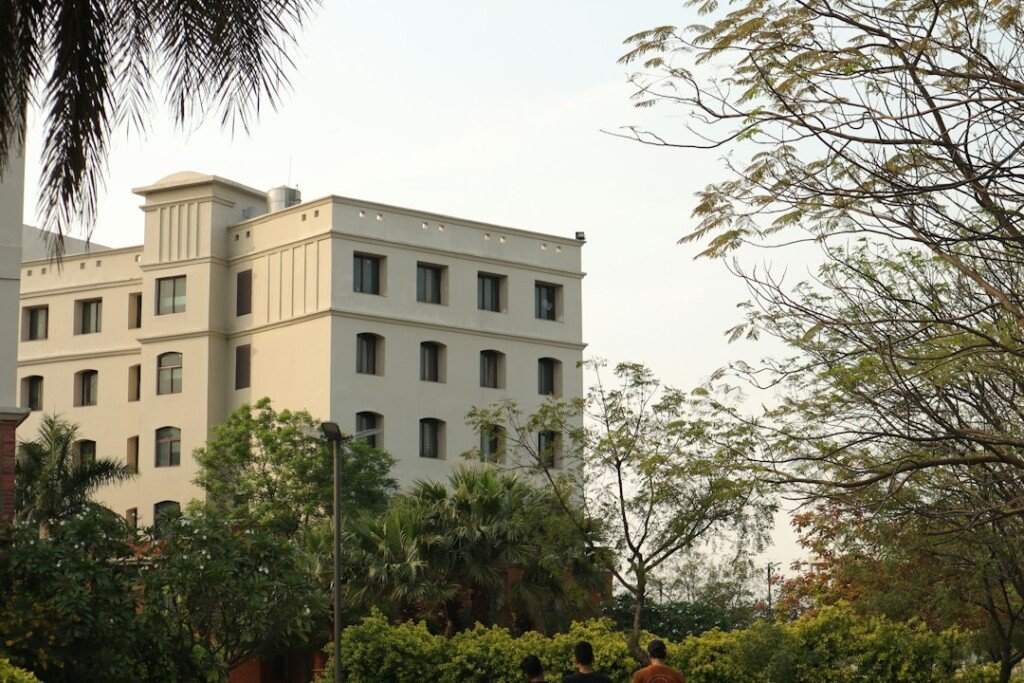 Two students walking in front of a large white university building