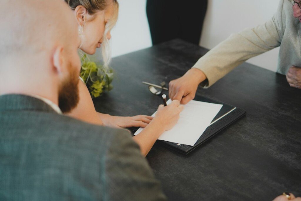 Two people signing a rental agreement document at a desk